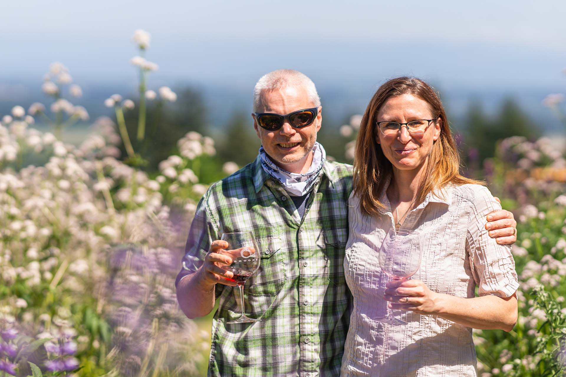 Happy couple in the vineyards, drinking Brooks Wine
