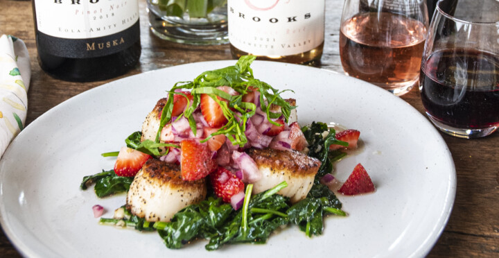 A white plate featuring seared scallops with strawberry salsa at Brooks Wine in Willamette Valley, Oregon. 